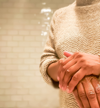 african-american woman rubs lotion on dry hands 1213885492