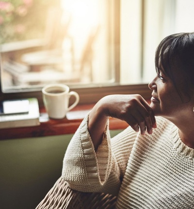 Woman With Drink Looking Out Of Window