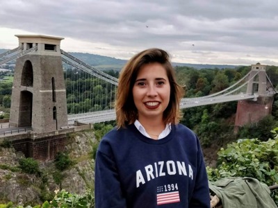 Marta elena vento, a woman with brown hair standing in front of a bridge