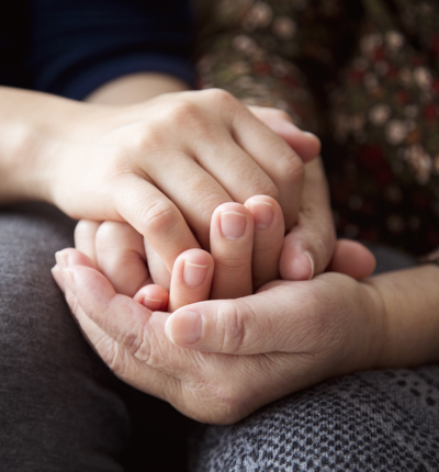 2 Women holding hands showing compassionate support