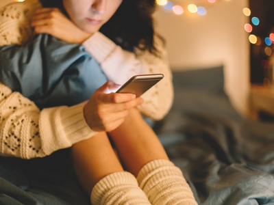 Girl in bed using phone