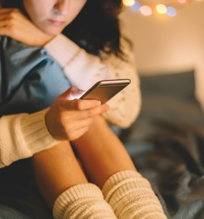 Girl in bed using phone