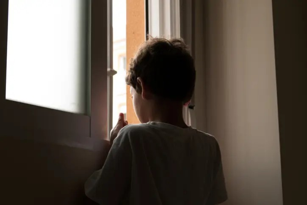 Boy Looking Out Of Window