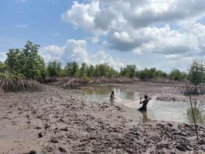 Members of Bodo community in a boat on waterway polluted by oil spills