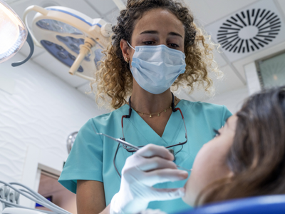 Female Dentist Looking Down With Tool