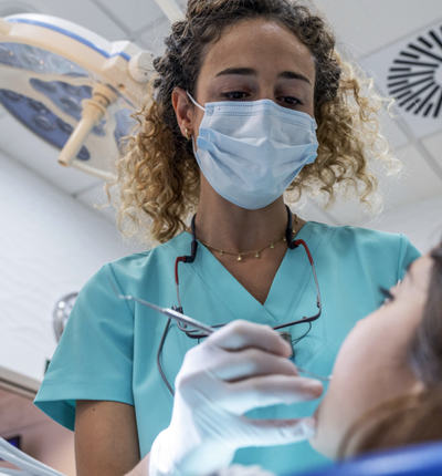 Female Dentist Looking Down With Tool